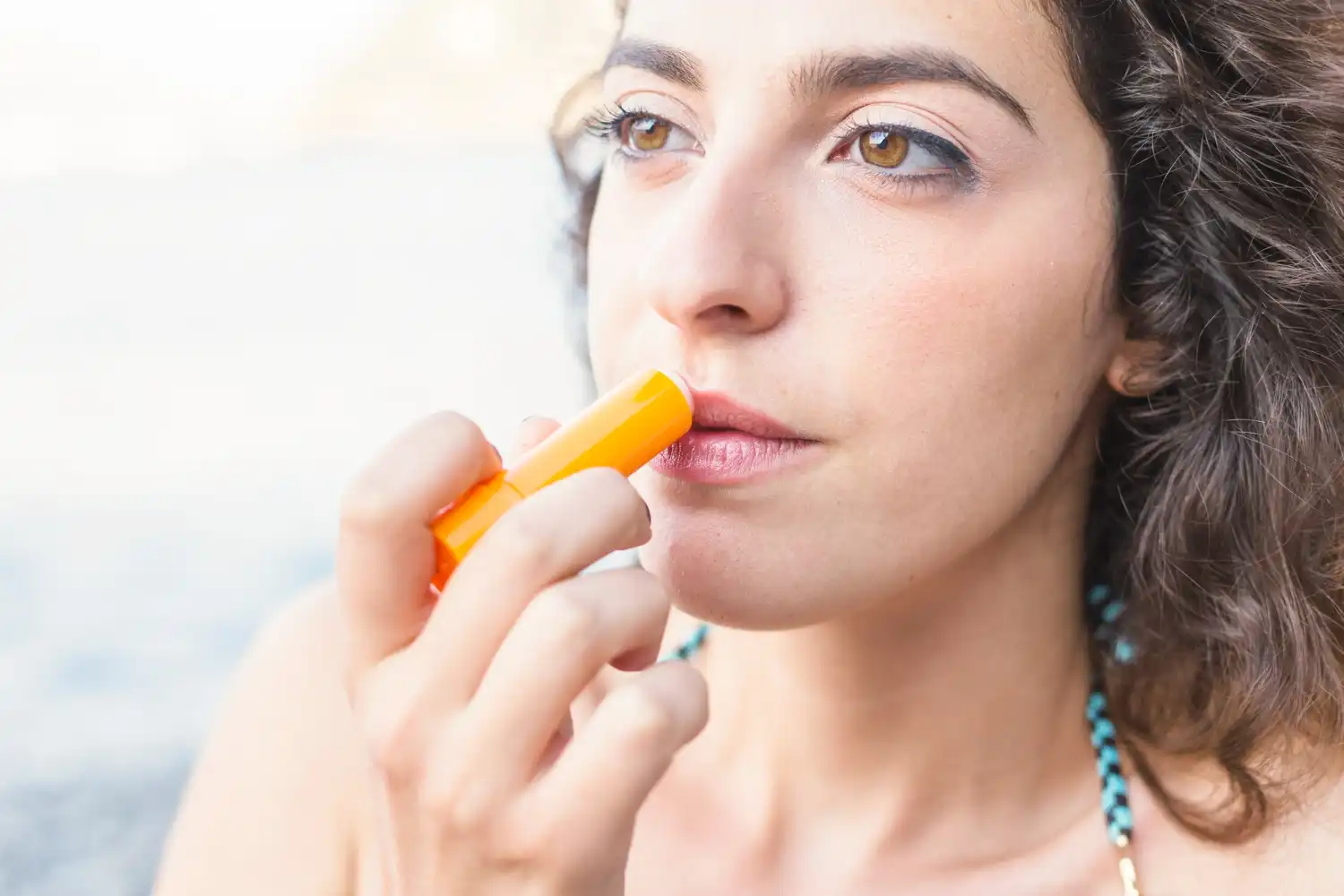 mujer morena aplicando crema para herpes labial