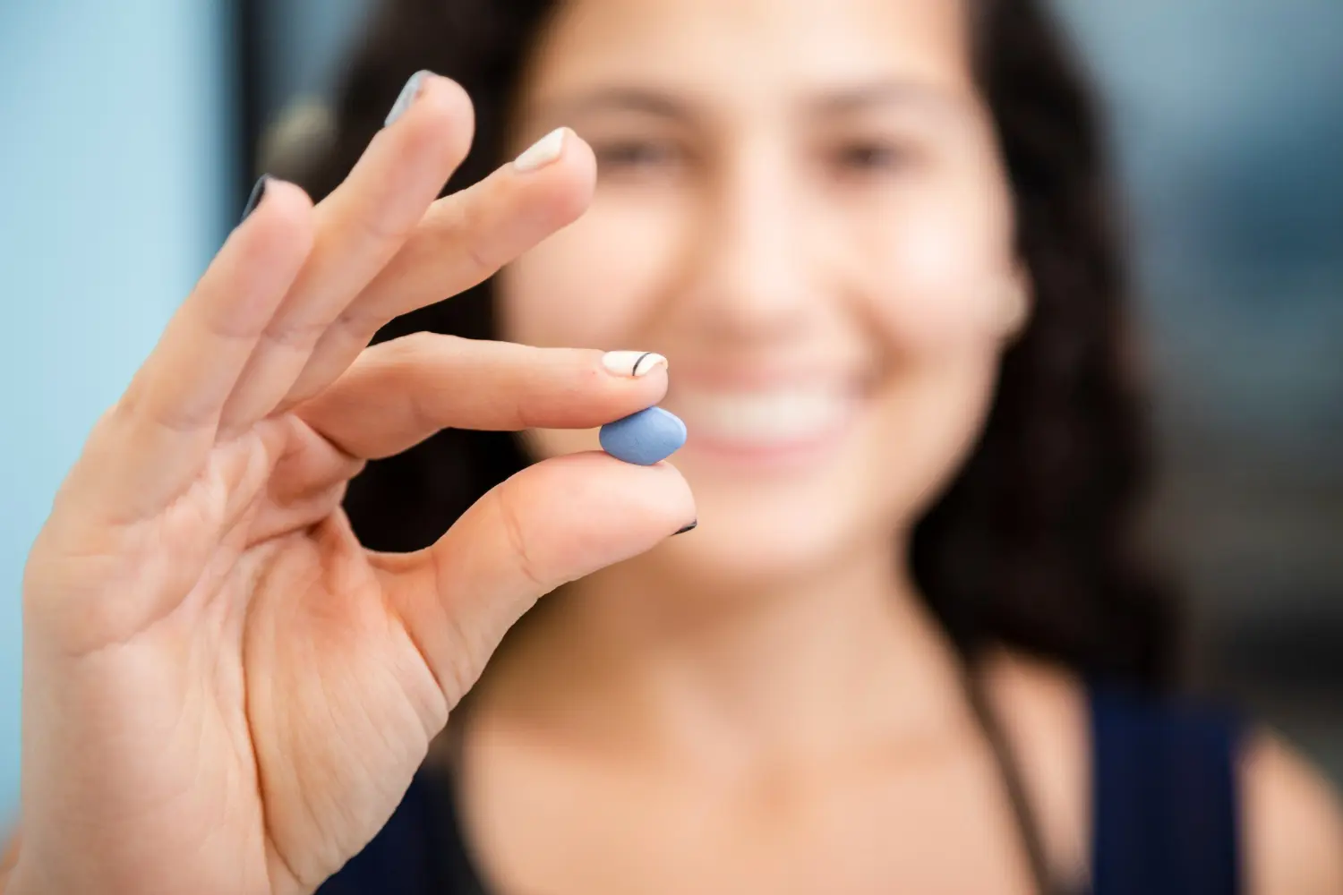mujer tiene una Pastilla azul para la regla