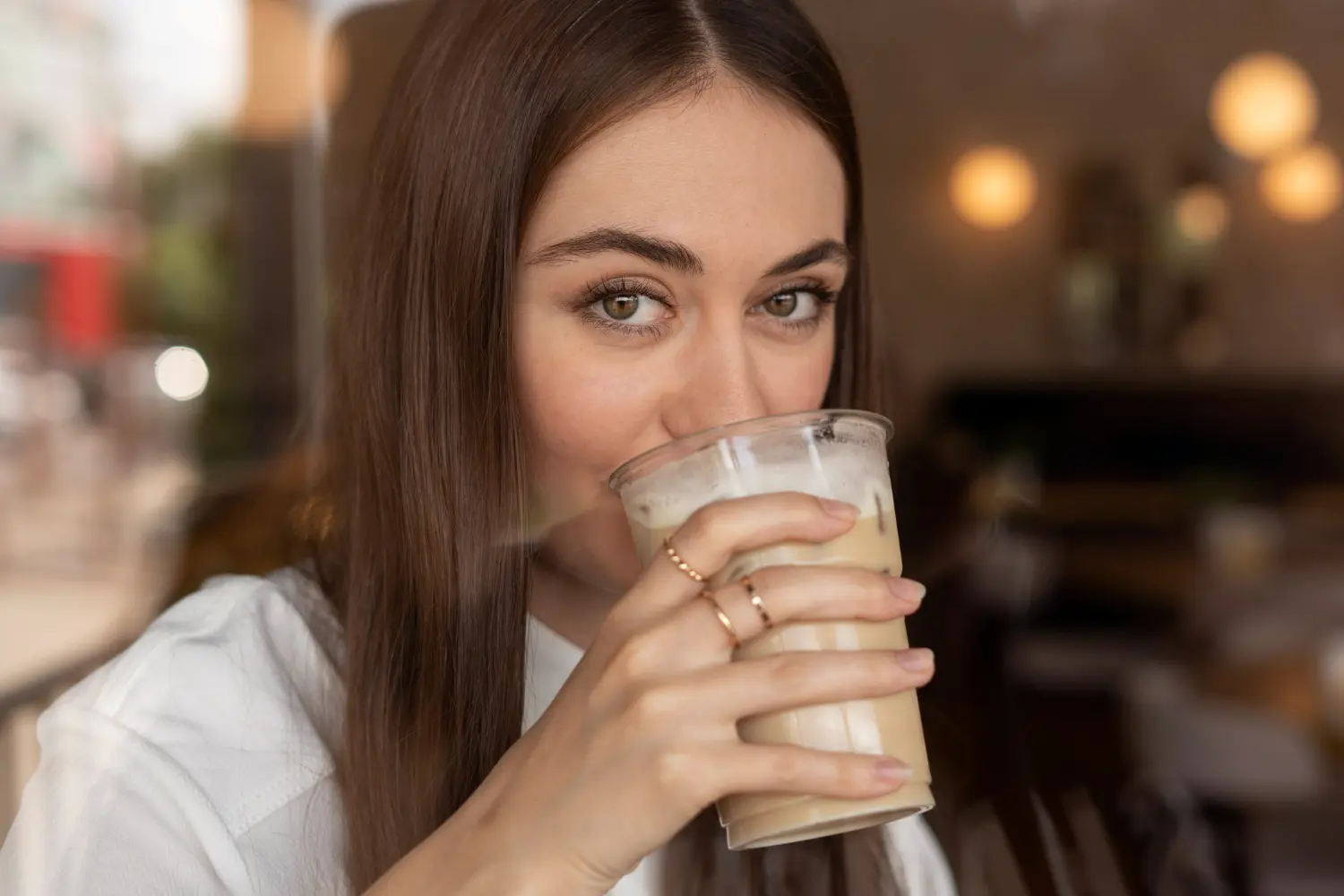 mujer valenciana bebiendo un vaso de horchata
