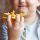 niño obeso con patatas fritas en la mano