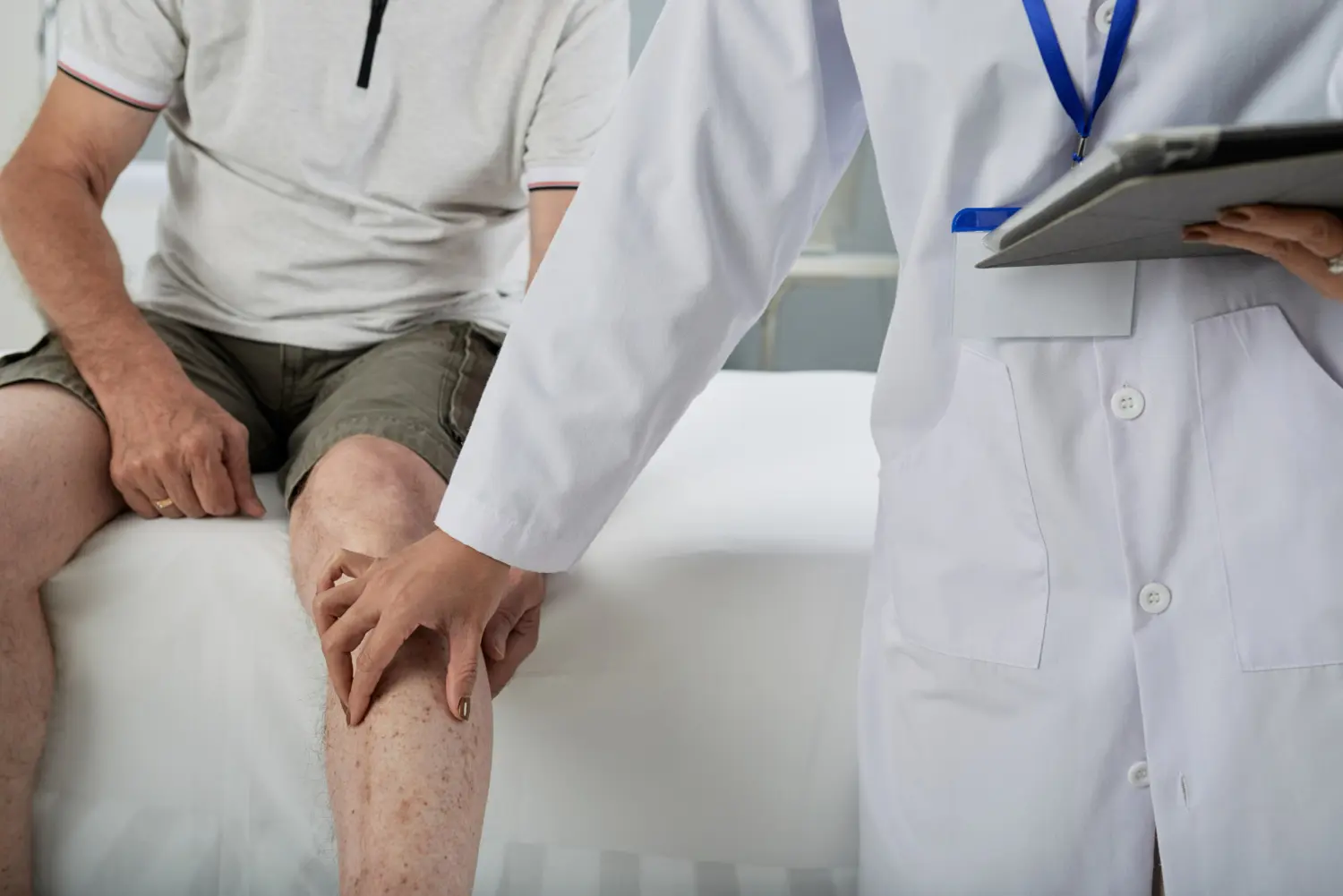 ortopeda toca chico con líquido en la rodilla
