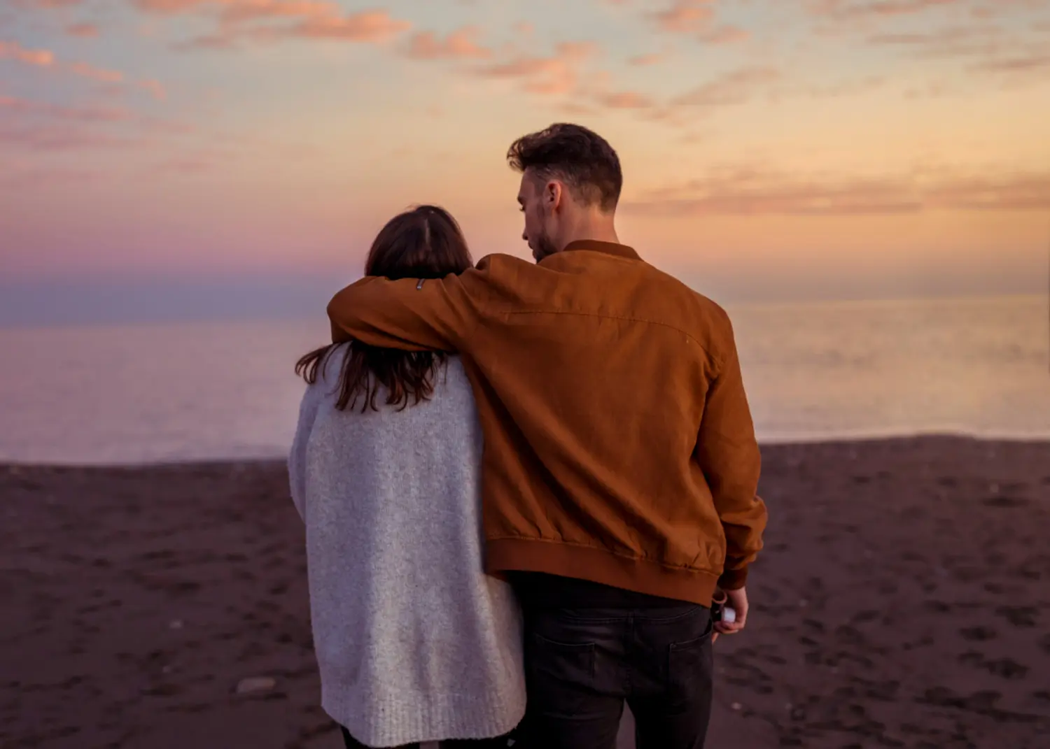 pareja abrazada delante de puesta