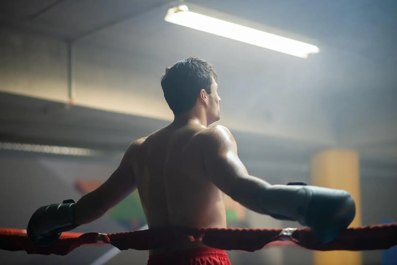 un boxeador con brazos descansando en cuerdas