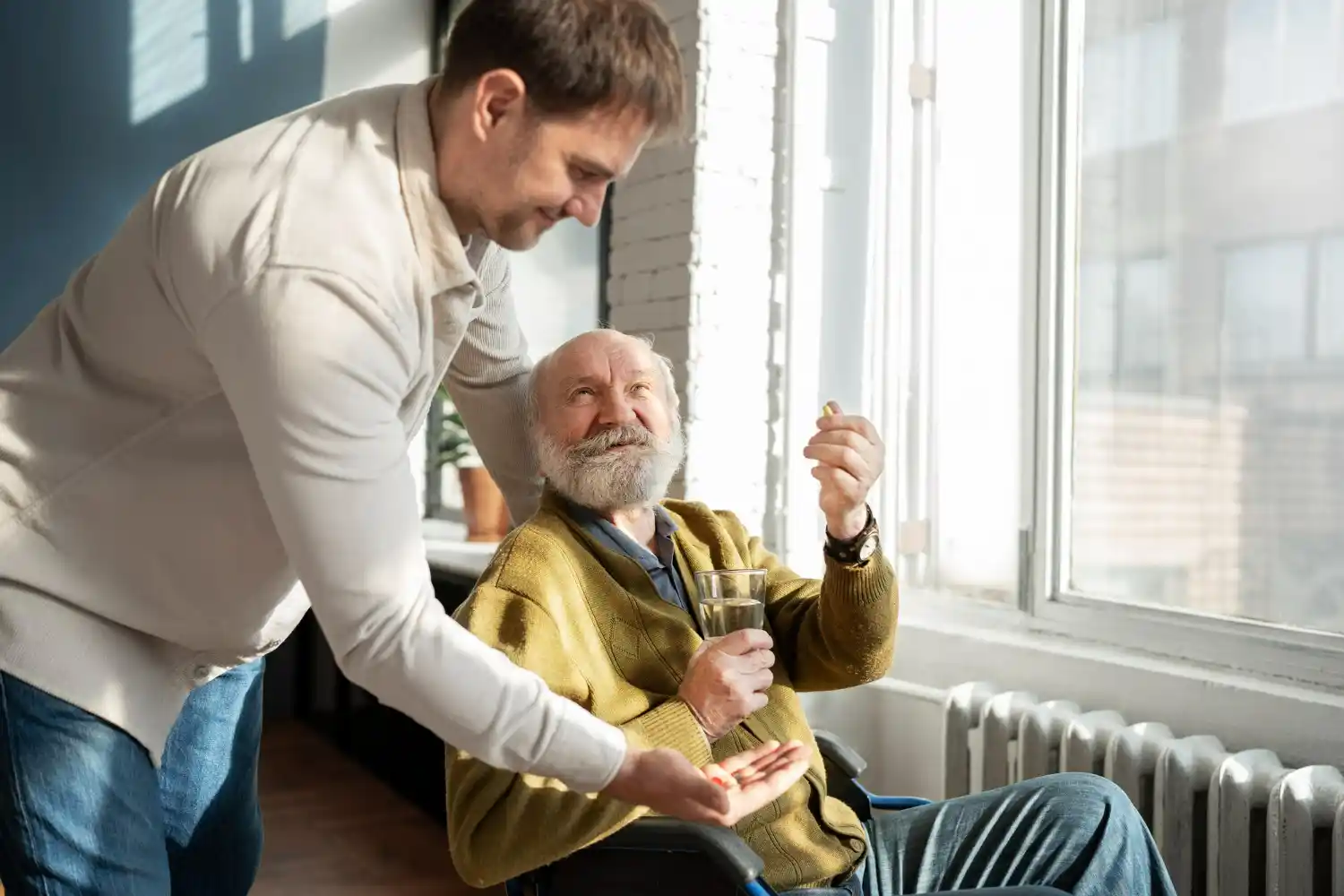 un gerocultor ayudando a un abuelo con agua