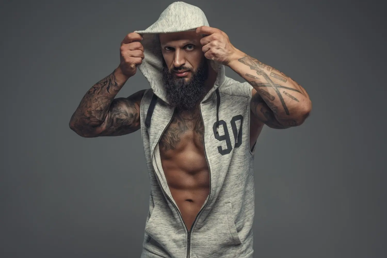 un rapero con tatuajes se quita gorra
