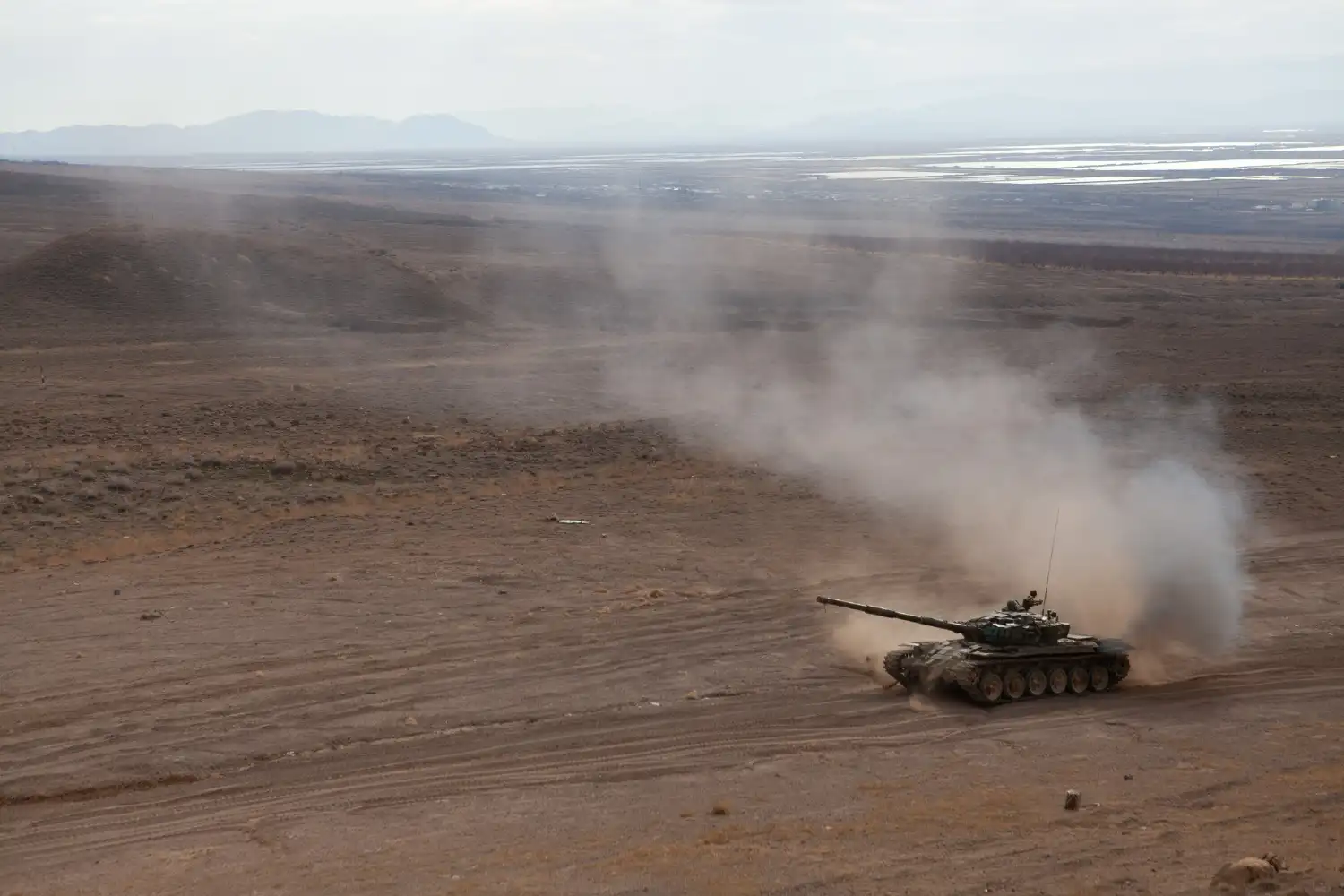 un tanque de guerra en arena hace polvo