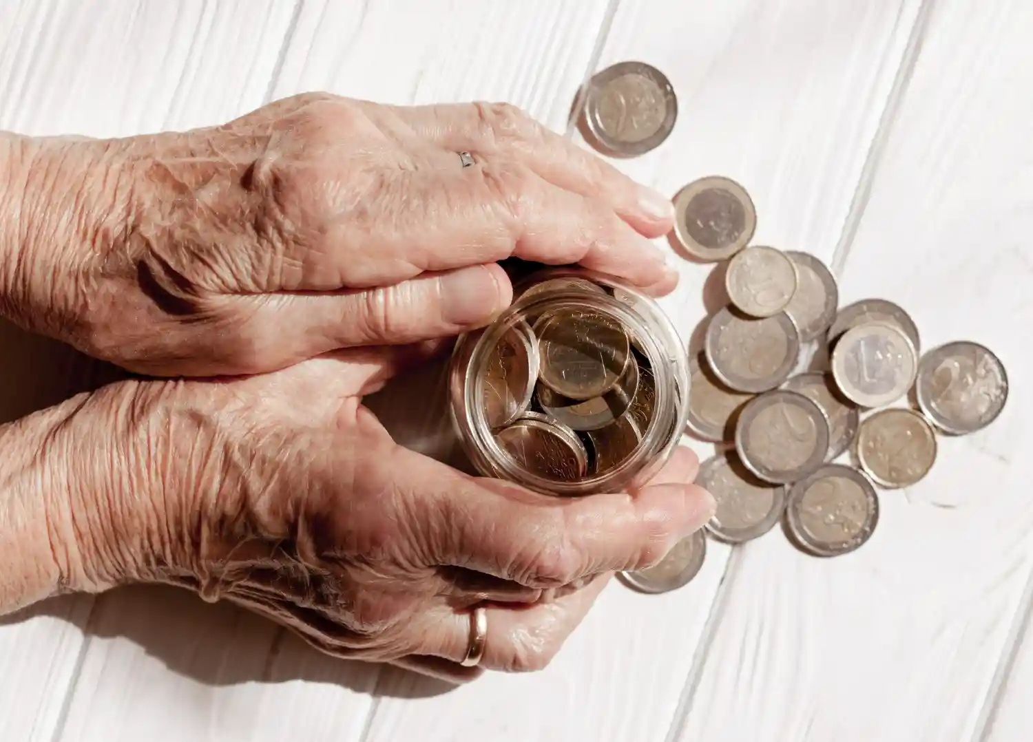 manos de ancianos con monedas euros