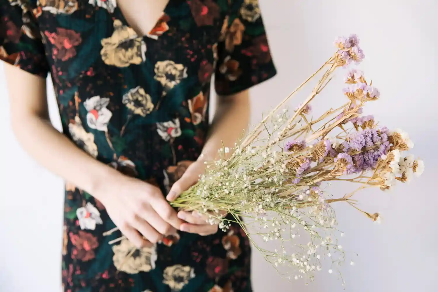 mujer sostiene ramo de flores secados