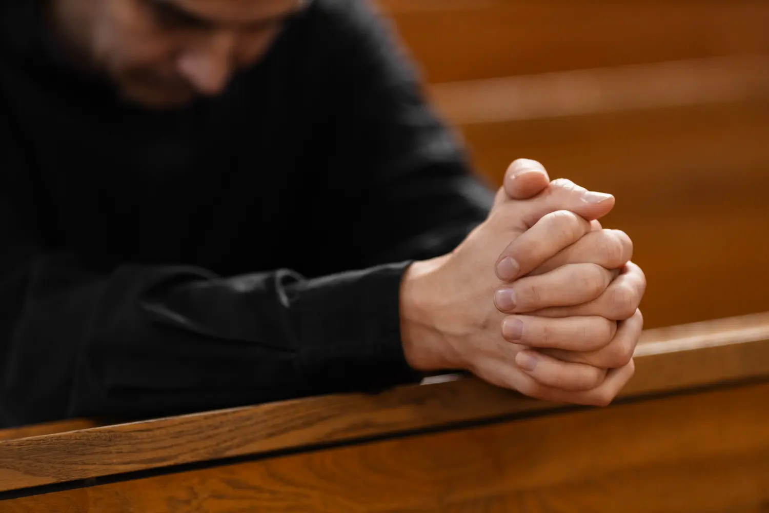 manos de un cura rezando en una iglesia