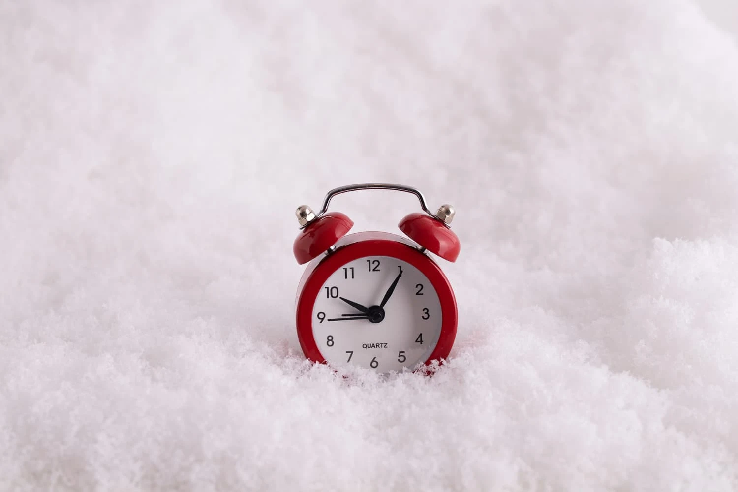 un reloj rojo hundido en la nieve