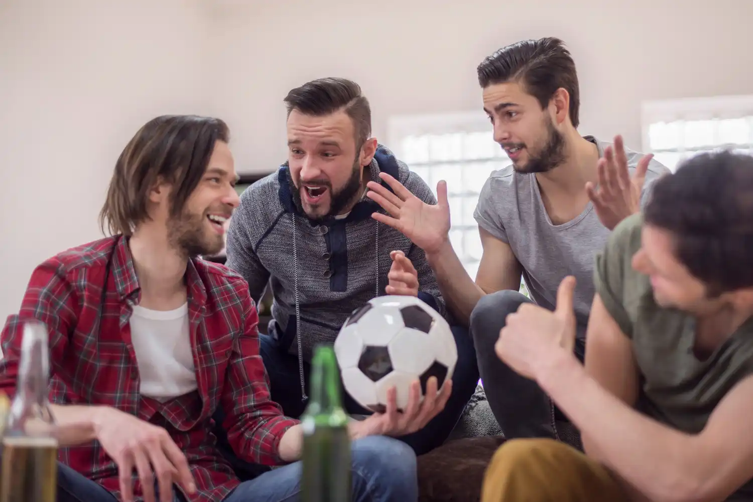 cuatro amigos con balon viendo futbol