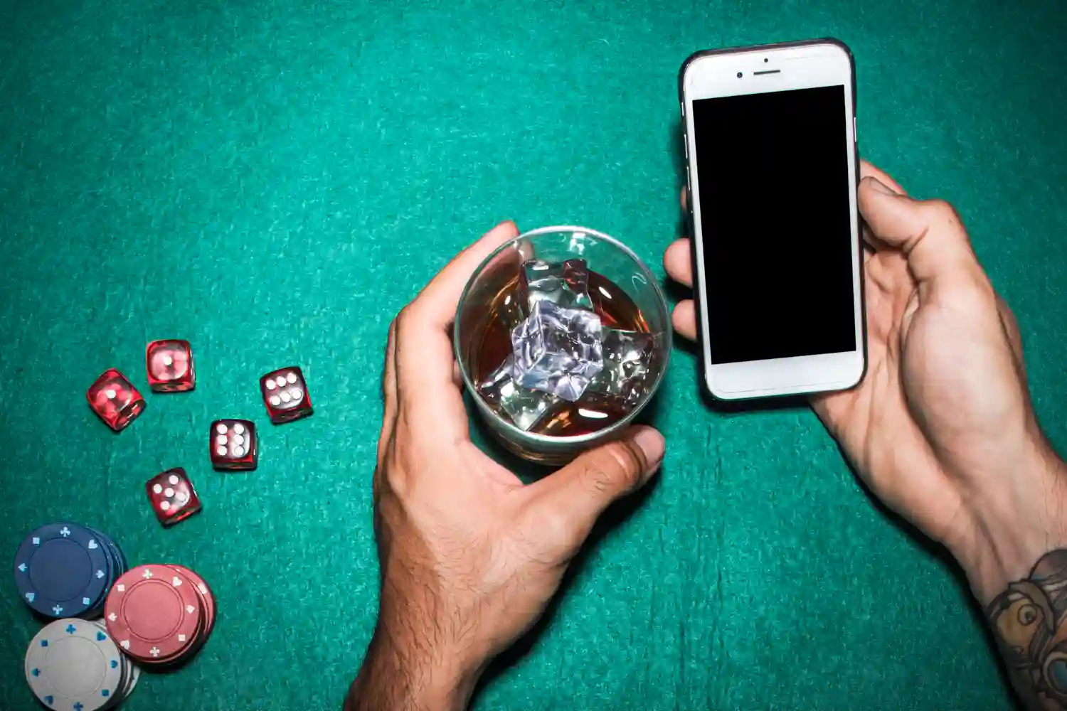 manos movil con vaso y mesa poker