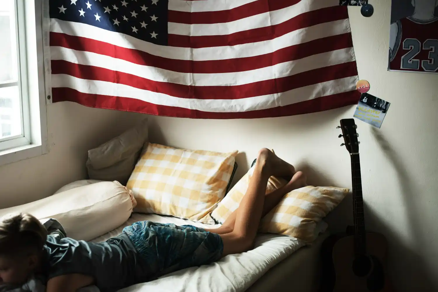 chico en cama con bandera de eeuu