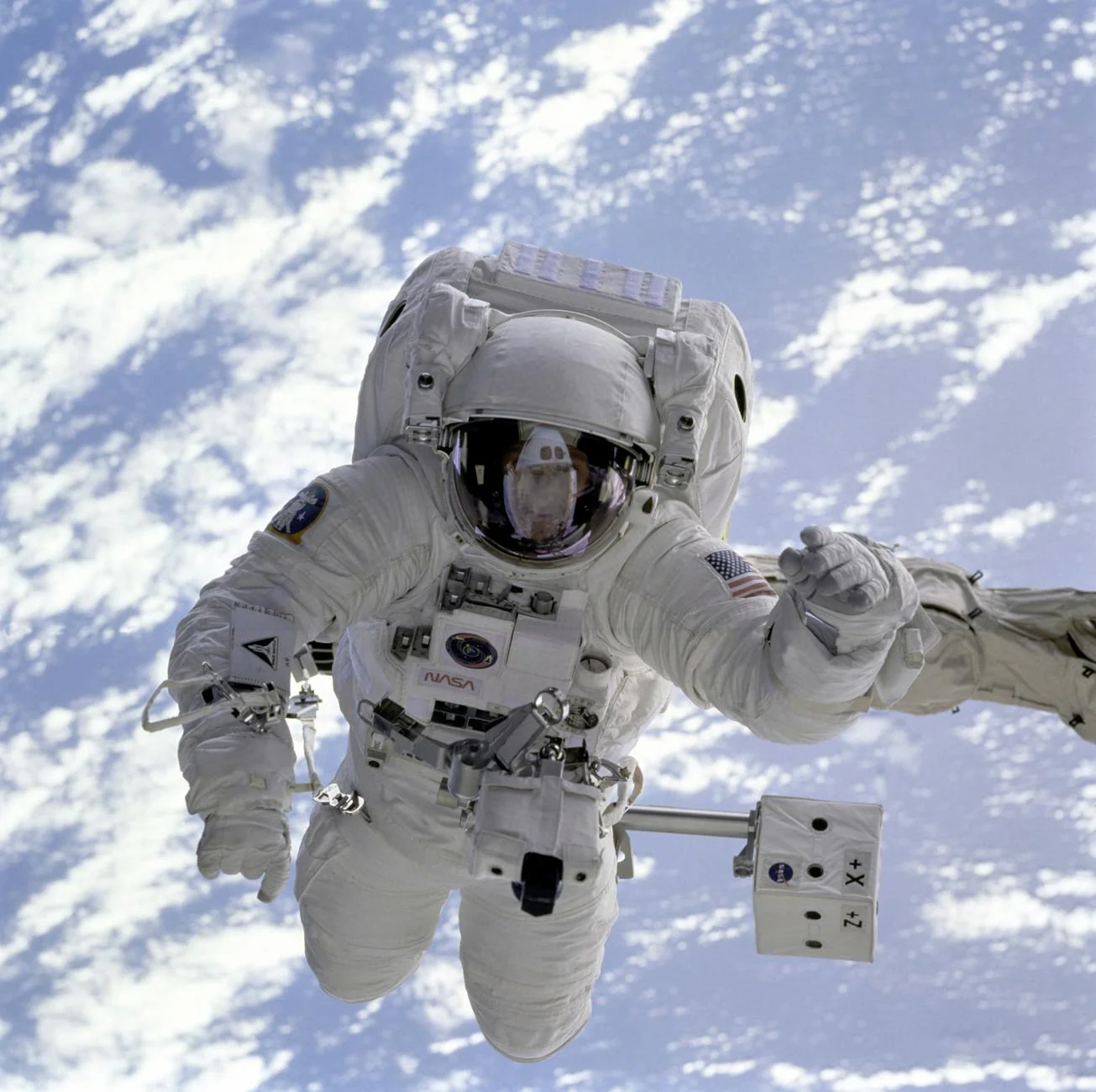 Astronauta haciendo una caminata espacial sobre fondo oscuro para ilustrar porque no hay luz en el espacio.