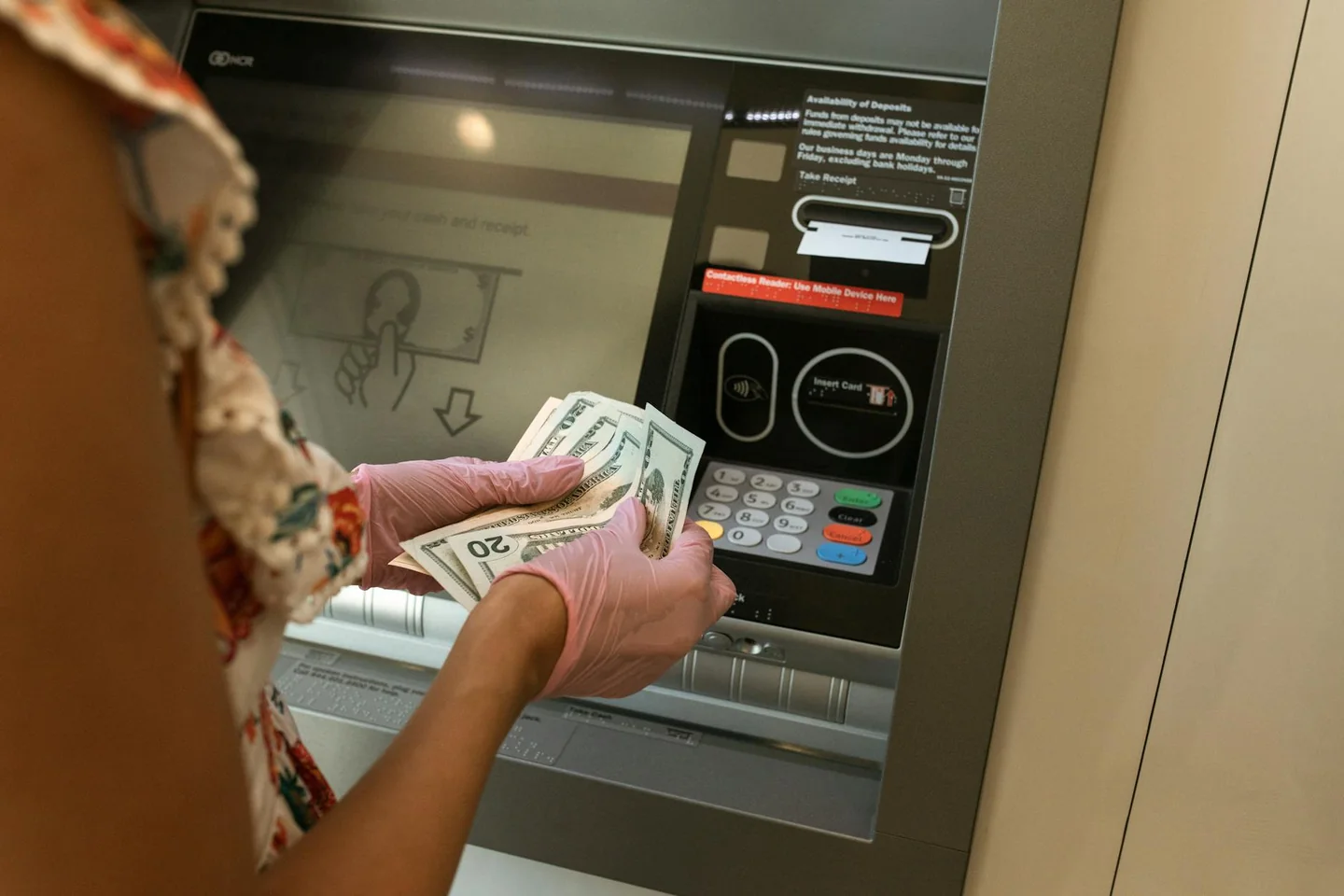 Persona usando un cajero automático para hacer un ingreso, ilustrando porque no puedo ingresar dinero en mi cuenta caixabank