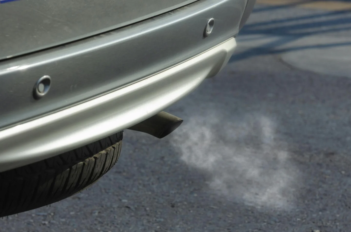 Imagen de un coche expulsando humo negro del escape, útil para explicar porque sale humo negro del tubo de escape en un artículo sobre causas y revisión del motor.