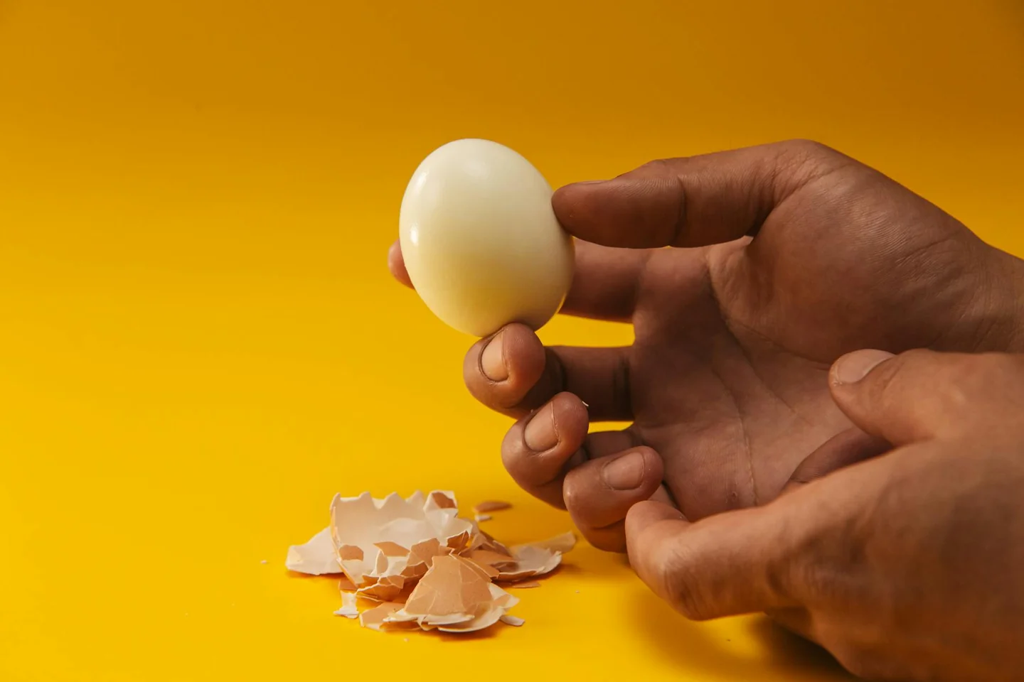 Primer plano de huevos cocidos pelados a medias para ilustrar porque se pelan mal los huevos cocidos