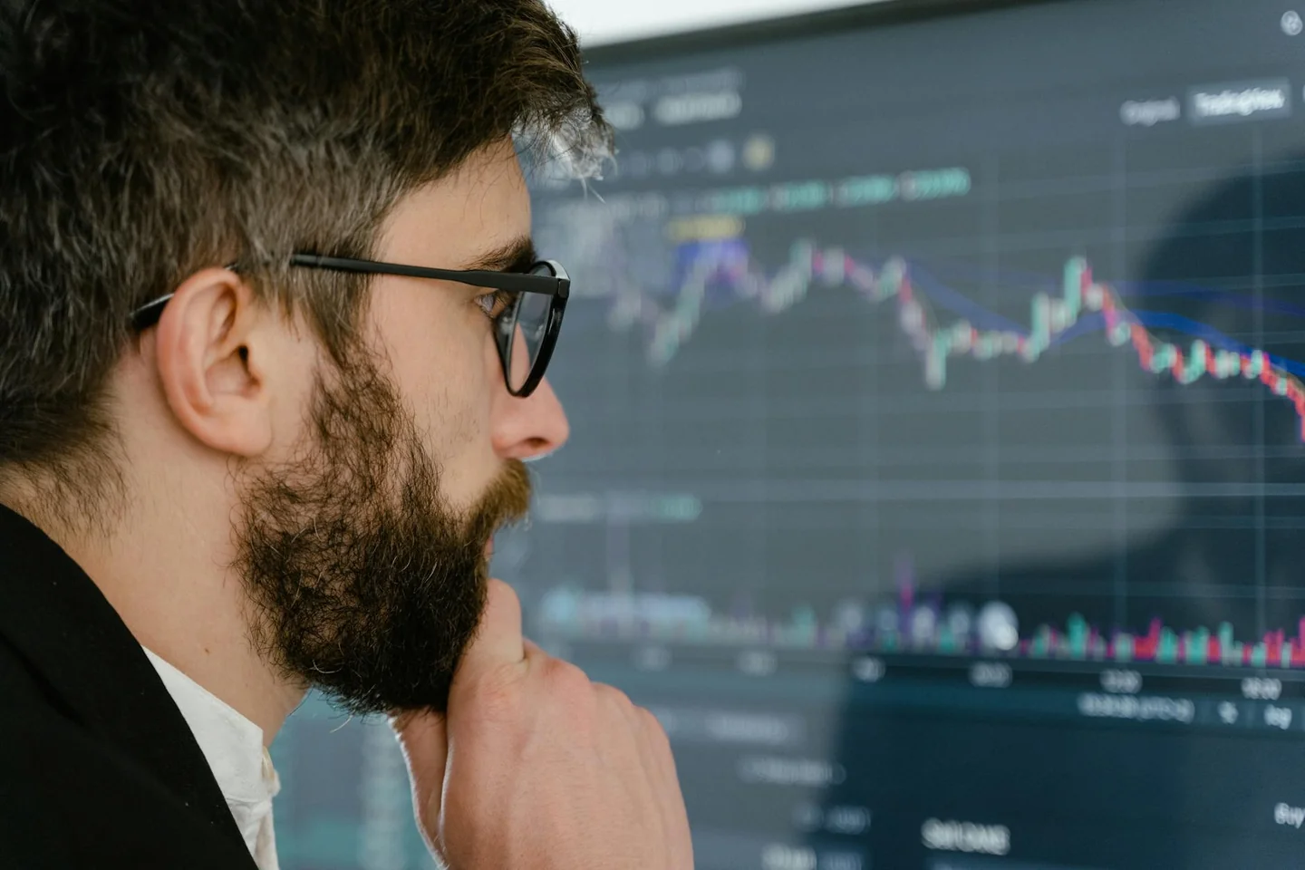 Hombre de negocios mirando un gráfico bursátil para ilustrar porque no suben las acciones de telefónica