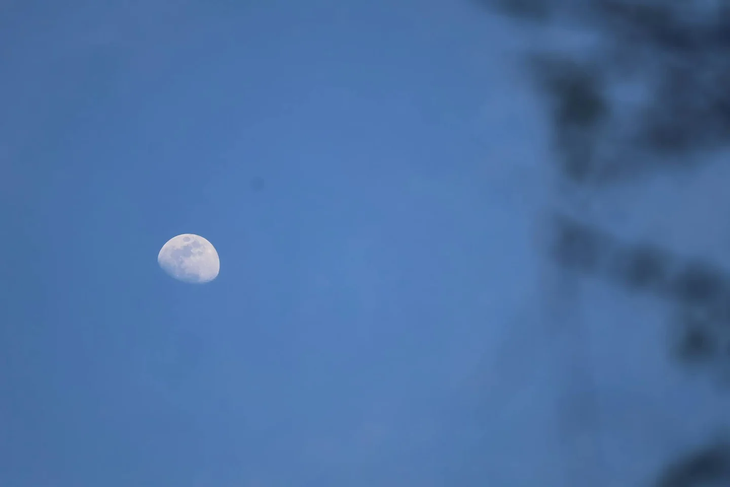 La imagen muestra la luna durante el día, ideal para explicar porque se ve la luna de dia en el cielo azul.