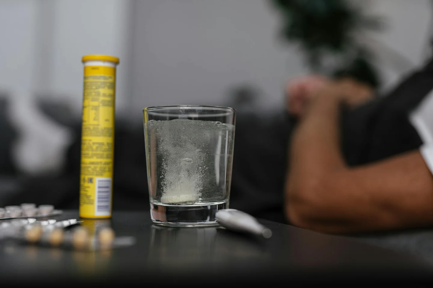 Persona dudando frente a una bebida porque últimamente me sienta mal el alcohol, en un contexto de medicación y malestar digestivo.