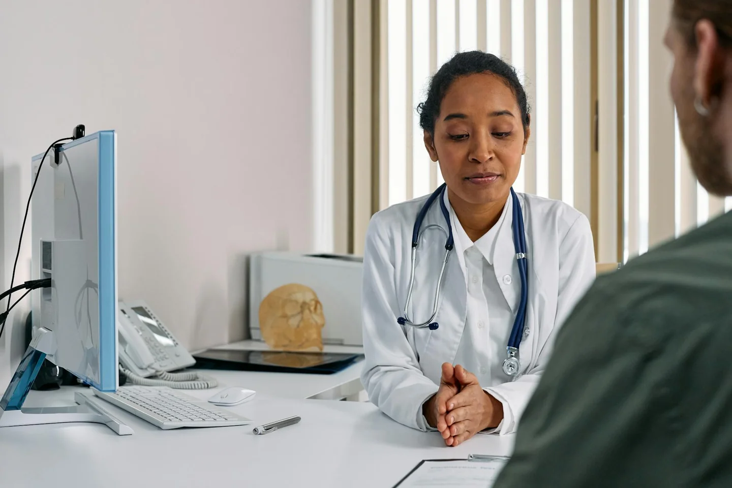 Mujer en consulta médica por que la mujer se orina al tener relaciones, hablando con una doctora sobre síntomas urinarios.