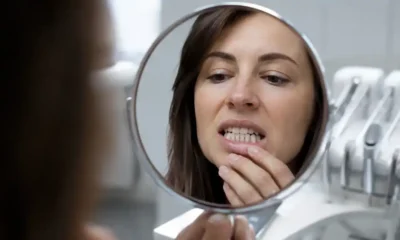 mujer mira dientes espejo