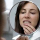 mujer mira dientes espejo
