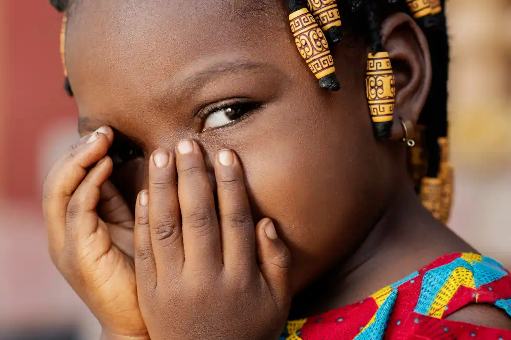 niña Kenia se tapa rostro