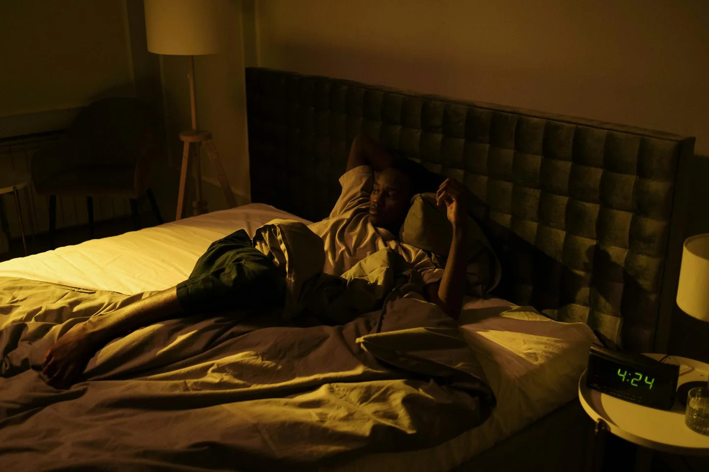 Persona tumbada y despierta en la cama, ilustrando porque pasa la paralisis del sueño durante la noche
