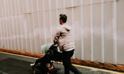 un peatón que empuja un carrito por dónde puede circular en una acera urbana estrecha