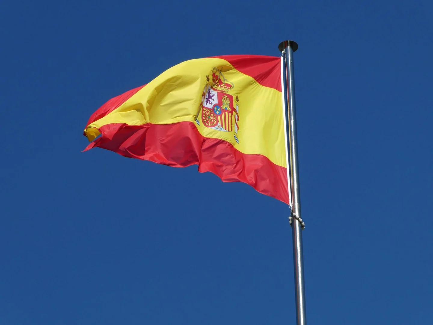 Imagen de una bandera de España ondeando, útil para ilustrar un artículo sobre porque la bandera de españa es roja y amarilla.
