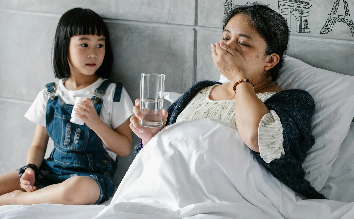 Mujer bebiendo agua junto a la cama, ilustrando porque se me seca la boca cuando duermo