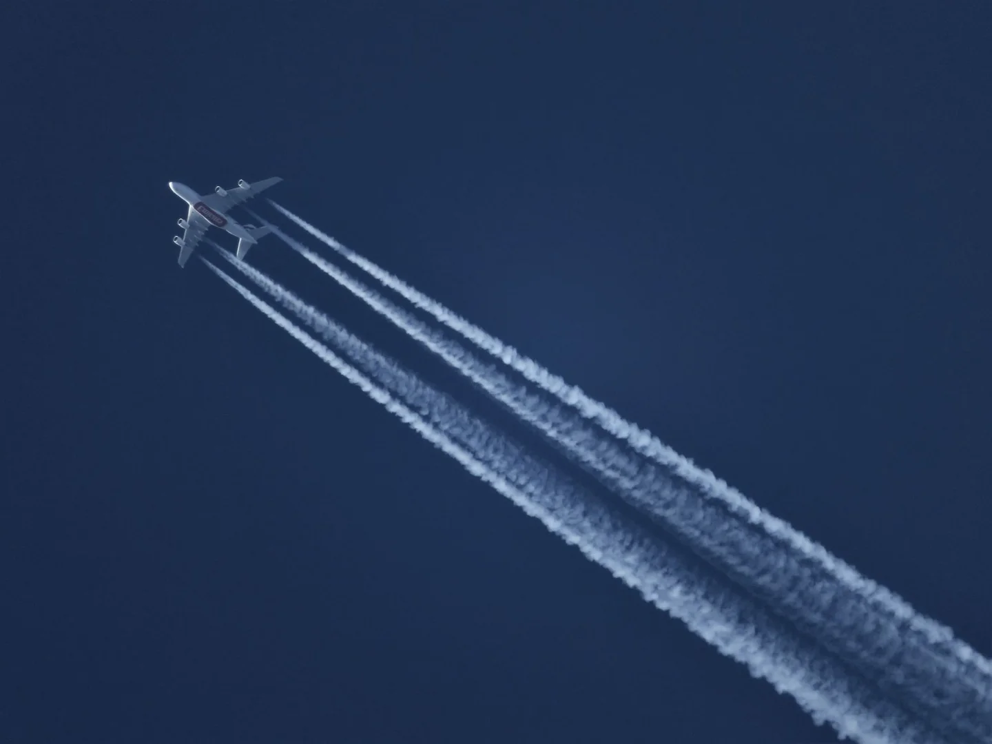 Imagen de un avión dejando una estela blanca en el cielo, útil para ilustrar por qué los aviones dejan estelas en el cielo.