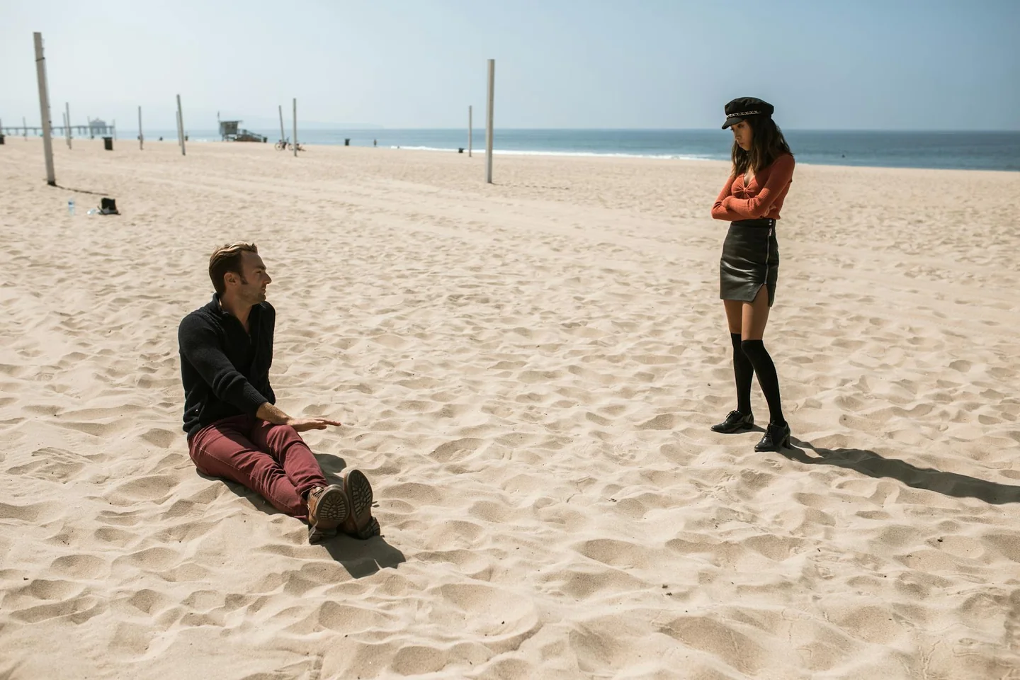 Pareja discutiendo en la playa sobre por qué las parejas discuten más en vacaciones