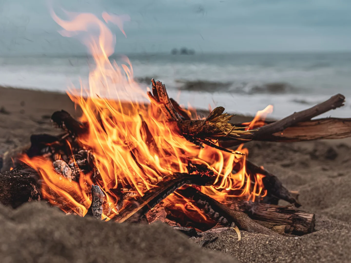 Fotografía de una hoguera en la playa relacionada con por qué San Juan mezcla santos fuego y solsticio, ideal para ilustrar la celebración de la noche de San Juan.