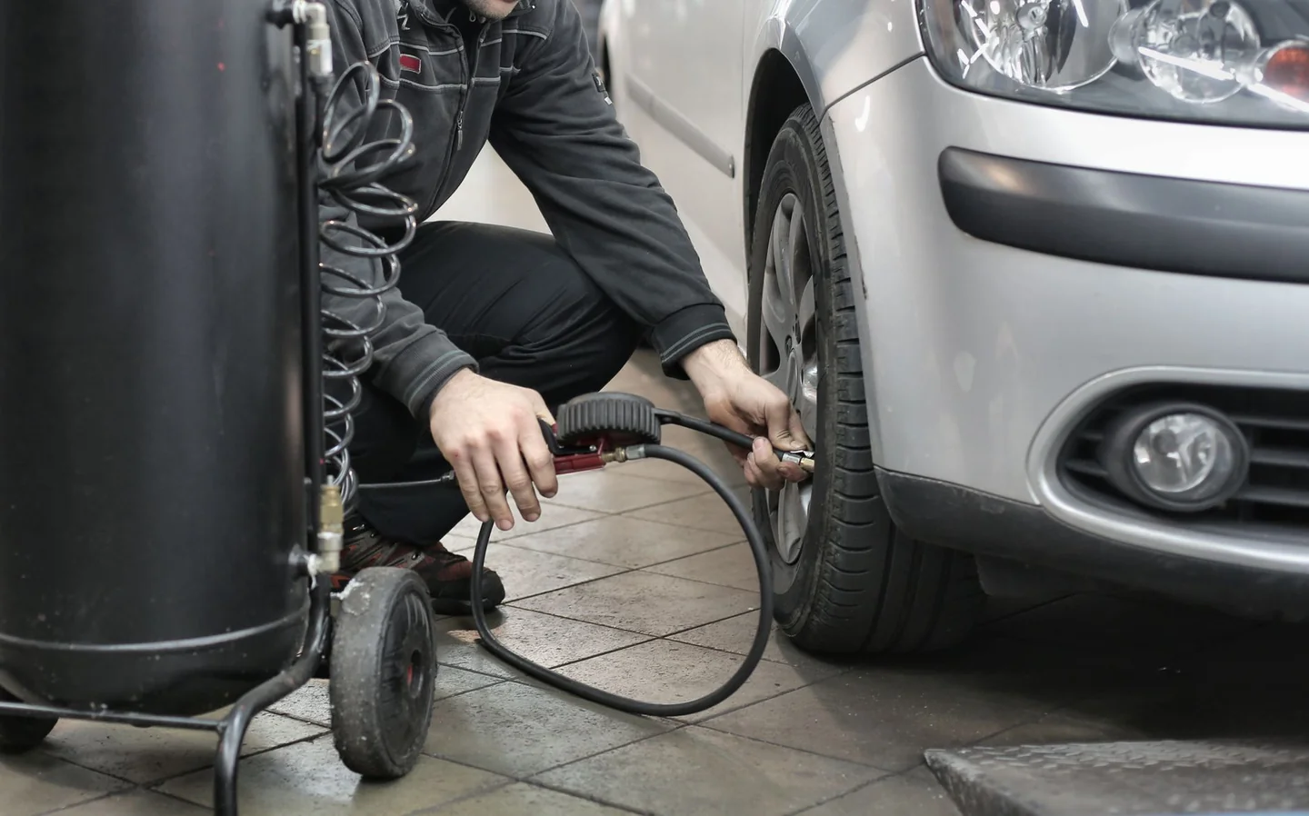 Medición de la presión de los neumáticos para ilustrar cómo ahorrar gasolina antes de la operación salida.