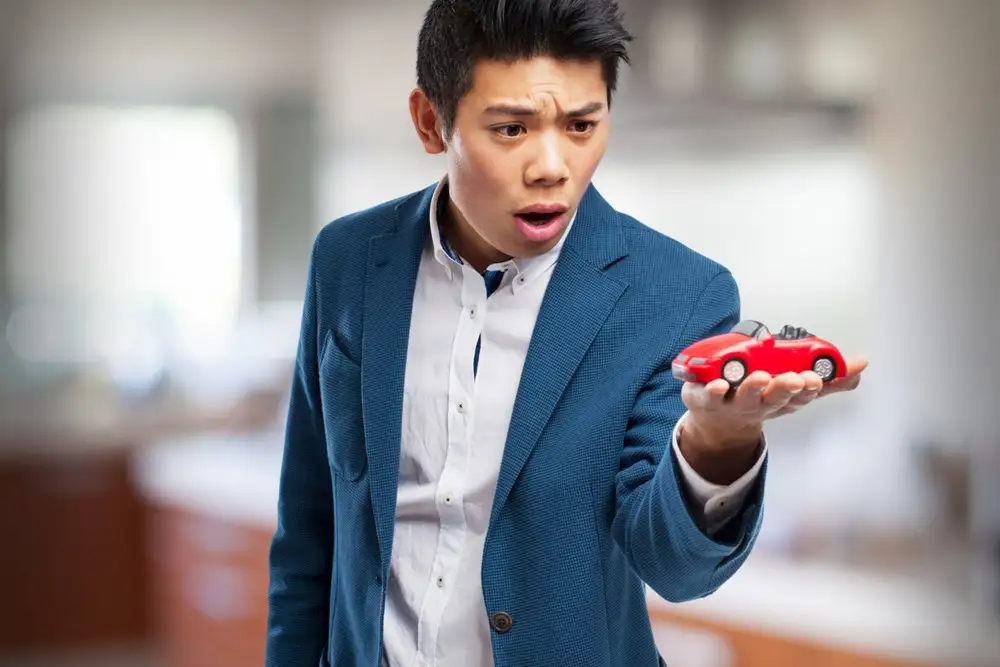 chino sujeta coche rojo