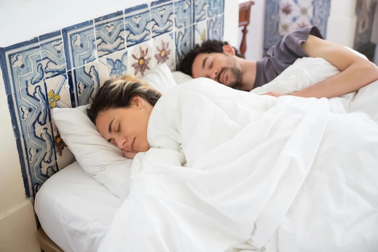 Imagen de una pareja sudando en la cama, relacionada con por qué el calor baja la libido en algunas parejas.