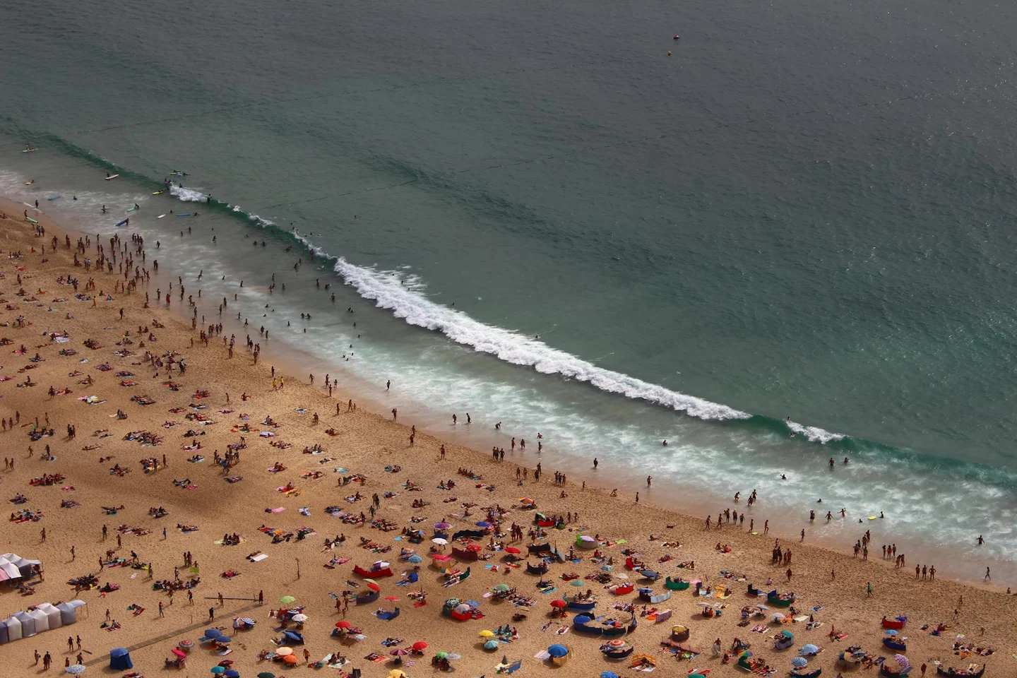 Fotografía de playa abarrotada para ilustrar qué destinos evitar si no soportas las multitudes durante el verano.