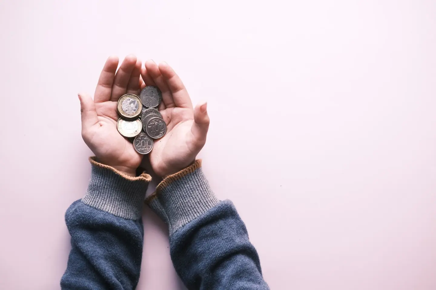 Manos sosteniendo monedas de euro para ilustrar cuenta remunerada o depósito en 2026