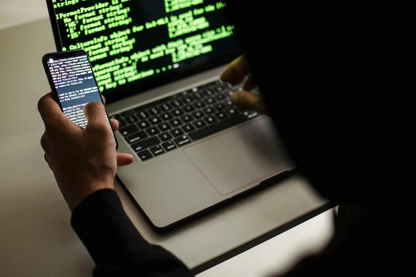 Imagen para qué es un infostealer y cómo roba contraseñas: un hacker con capucha frente a un portátil, ilustrando el robo silencioso de datos y credenciales.