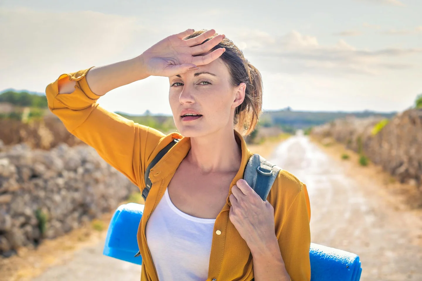 Mujer sudando y agotada por el calor, ilustrando por qué el calor aumenta la ansiedad en un día sofocante