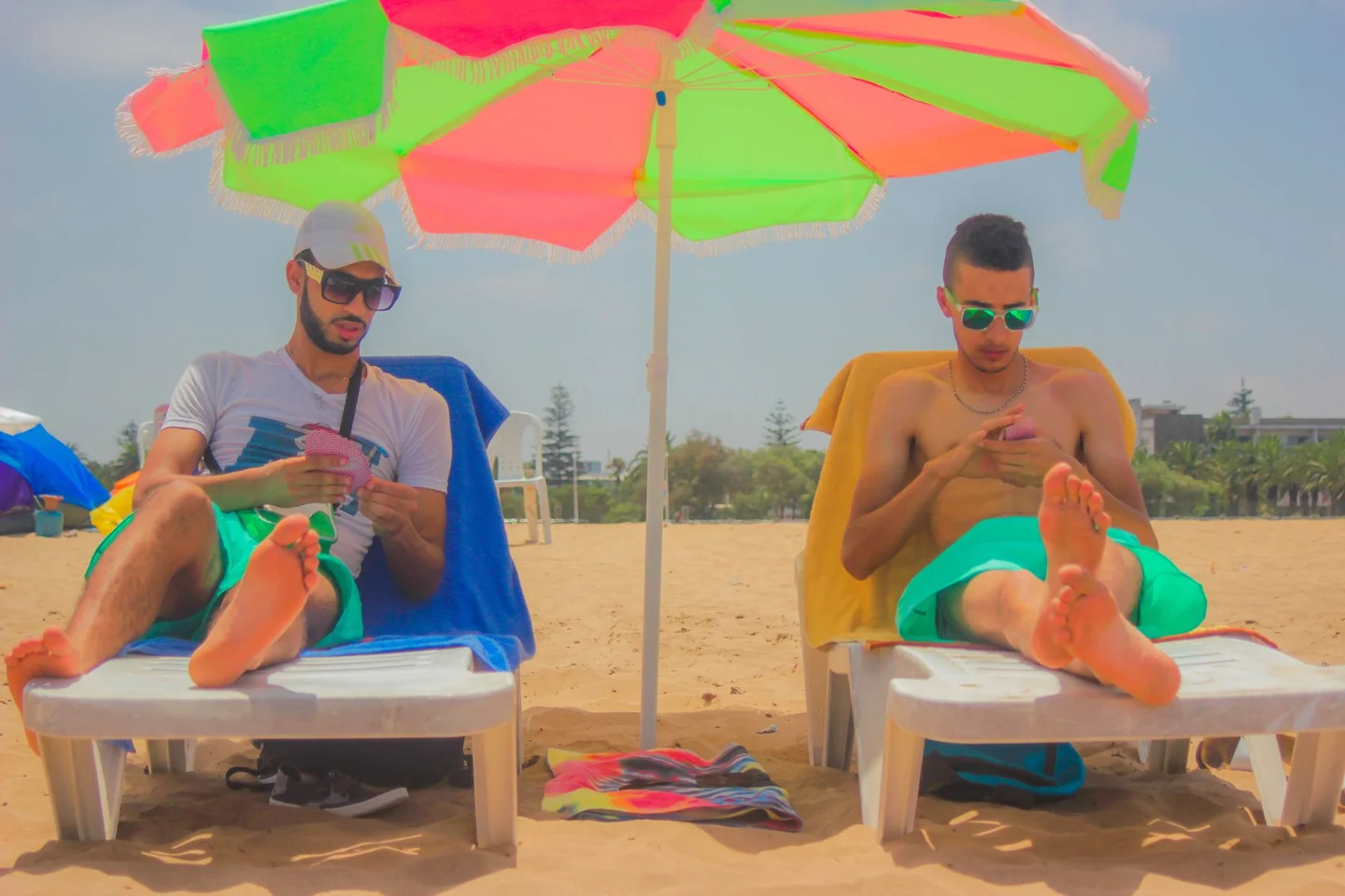 Imagen para explicar qué hacer si tu móvil se calienta en la playa, mostrando un smartphone sobre la arena bajo el sol.