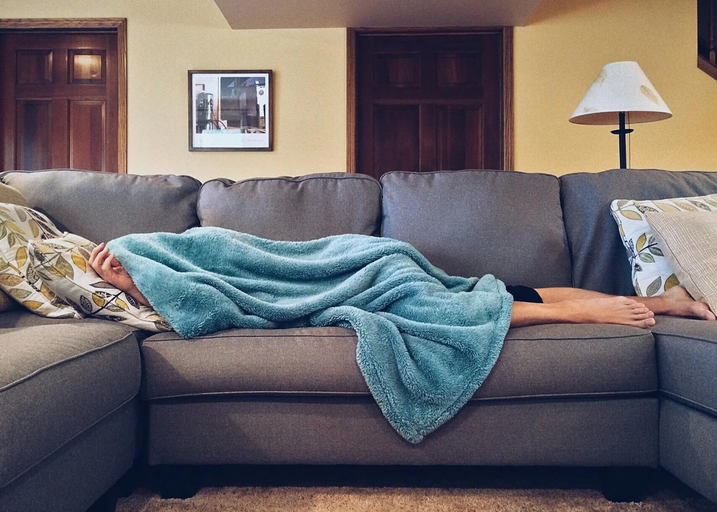 Imagen de una persona durmiendo la siesta en un sofá, asociada a qué era la siesta antes de ser tópico turístico.