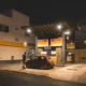 Imagen de una persona repostando un coche para ilustrar por qué no se puede usar el móvil en una gasolinera.