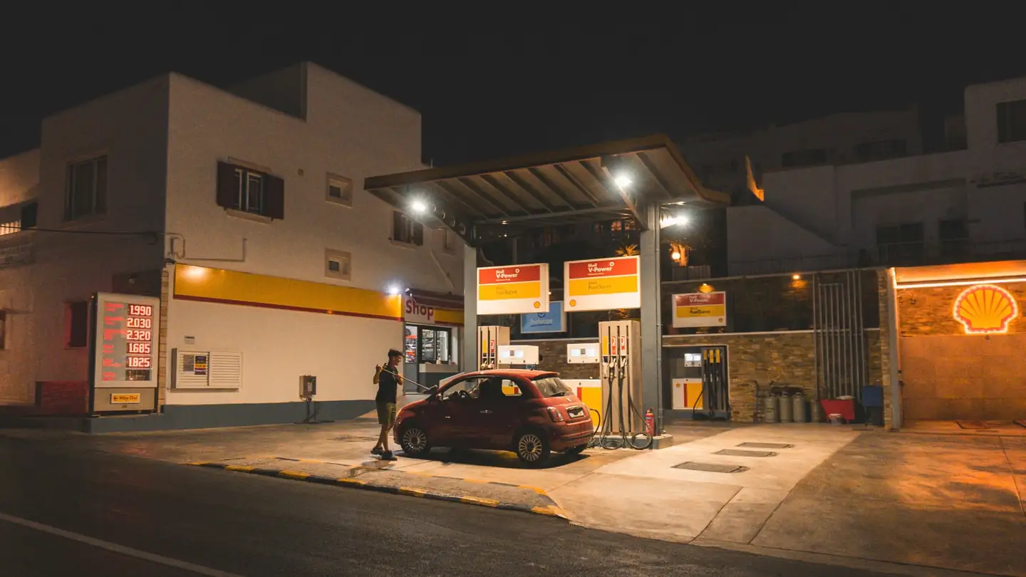 Imagen de una persona repostando un coche para ilustrar por qué no se puede usar el móvil en una gasolinera.