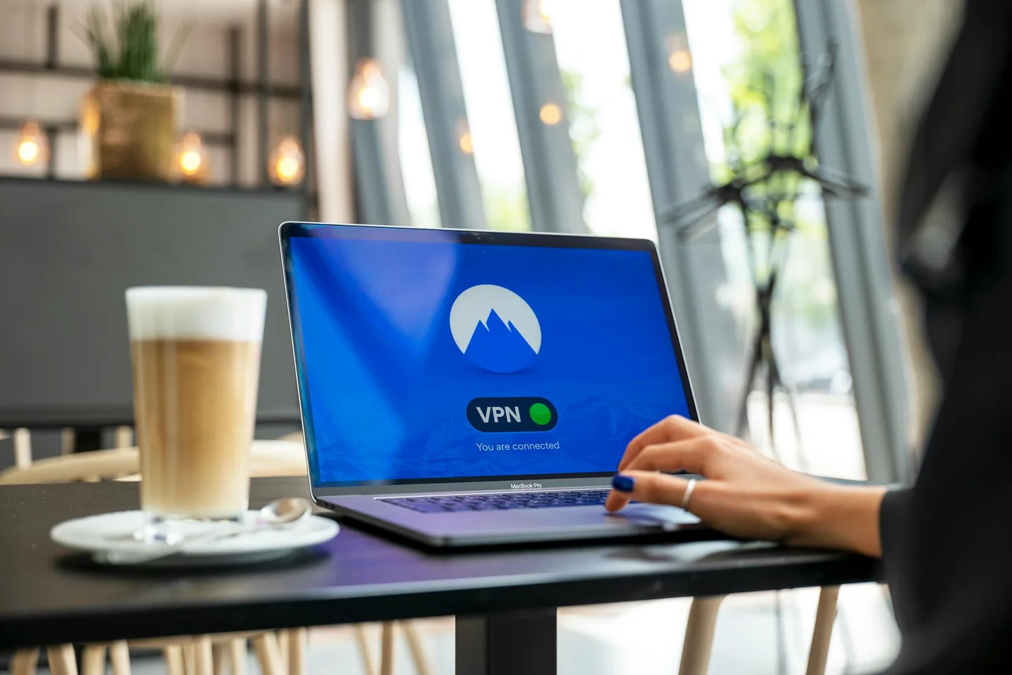 Persona usando una laptop mientras investiga cómo usar una VPN sin caer en falsas promesas en un entorno de trabajo digital.