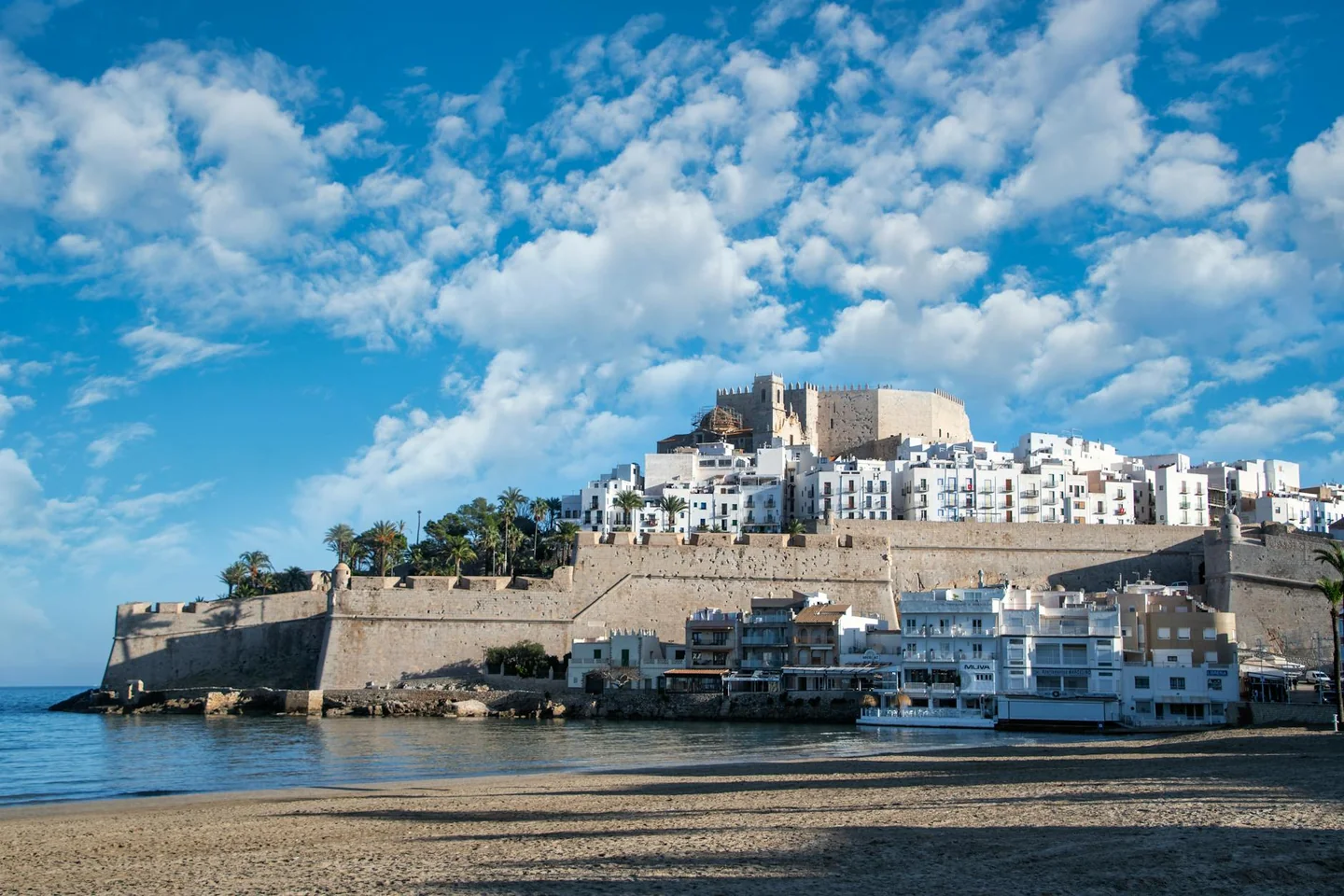 Vista de un pueblo costero español para ilustrar dónde viajar barato en España este verano sin caer en playas saturadas.