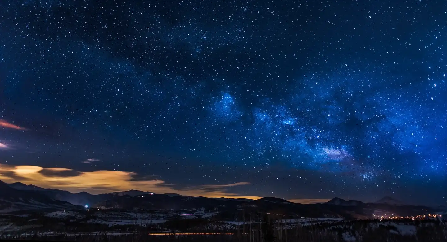 Paisaje nocturno para ilustrar lugares para ver estrellas en España, con montañas y cielo estrellado.