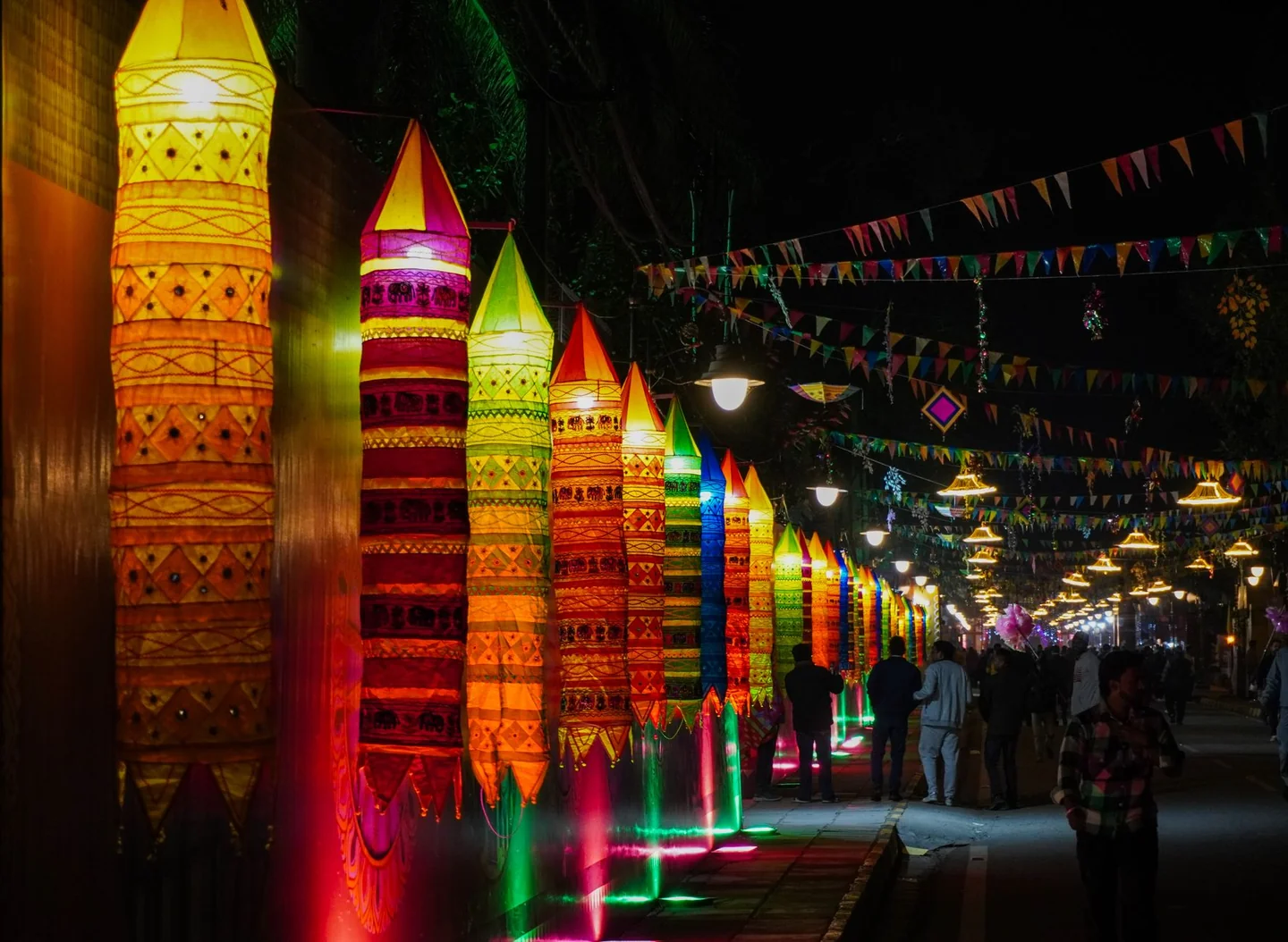 Imagen de una fiesta callejera nocturna con luces y ambiente festivo para ilustrar por qué las verbenas se llaman verbenas.